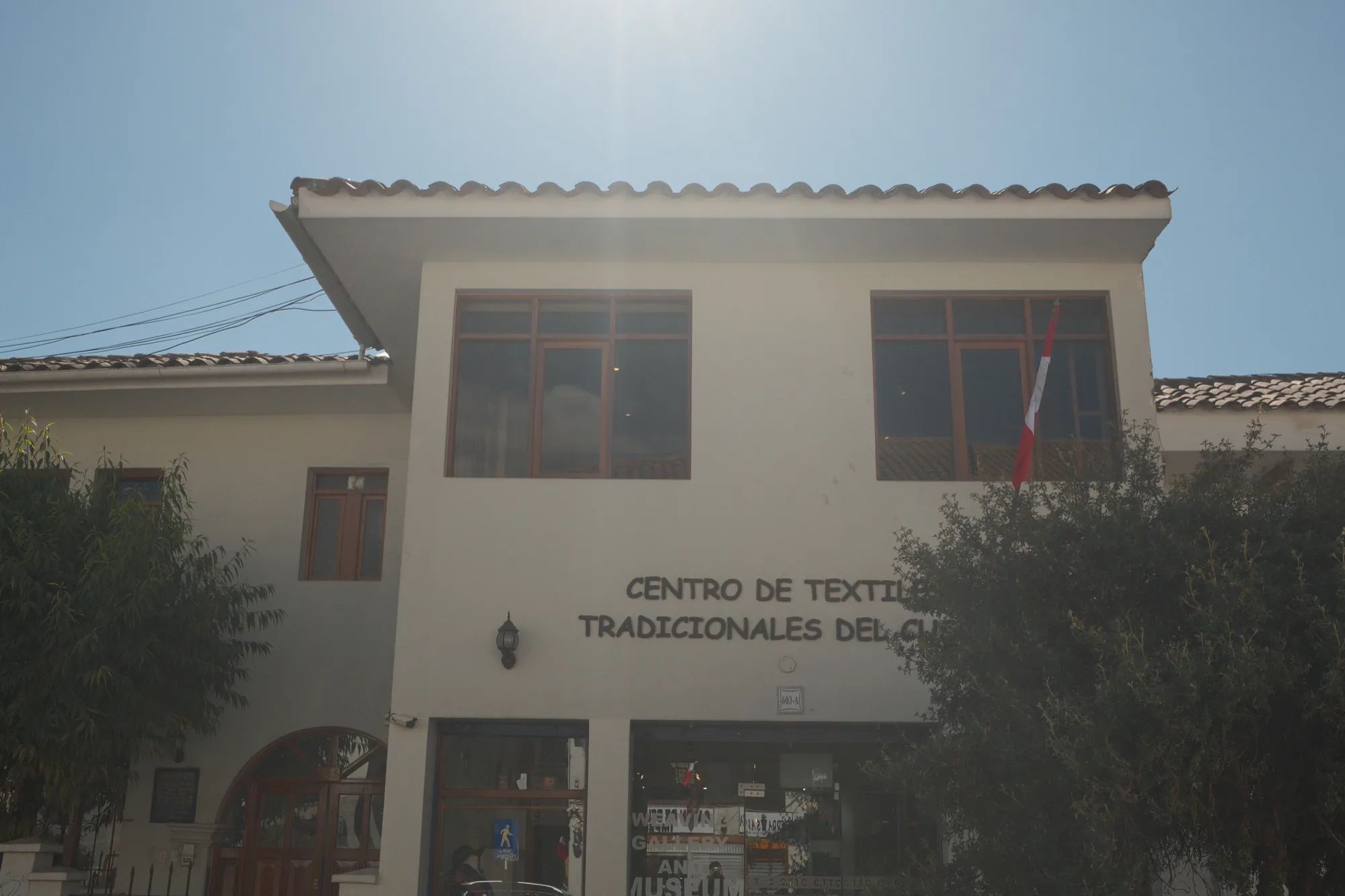 Die Aussenfassade des Centro de Textiles Tradicionales del Cusco unter blauem Himmel.
